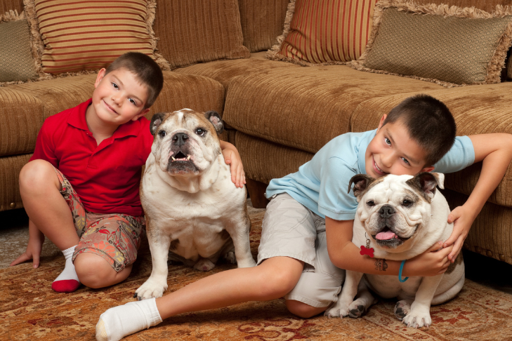 kid reading with family dog on the floor